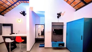 Una cocina moderna con comedor, un armario azul y un televisor montado en la pared.