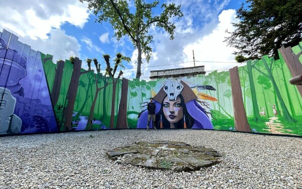 A mural with a forest theme, a peacock, and a skull.