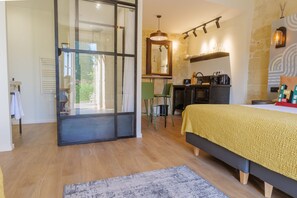 A bedroom with a bed, a desk, a chair, a mirror, and a view through a glass door. - When heritage, art and well-being meet (CANDES SAINT MARTIN)
