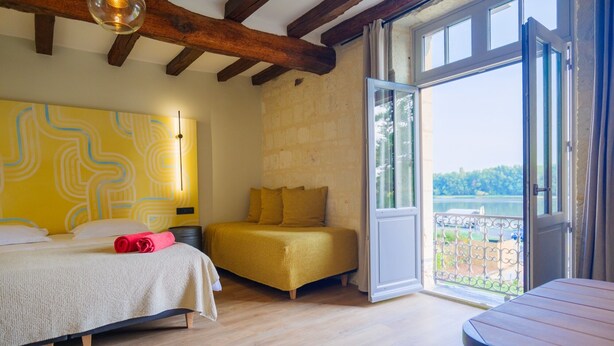 Una camera da letto con un letto, un divano, una finestra e un balcone.