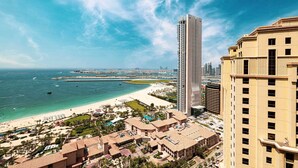 Um hotel à beira-mar com vista para a praia, um arranha-céu imponente e um porto de iates.