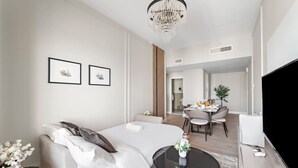 Quarto de hotel moderno com uma cama, área de refeições e televisão.