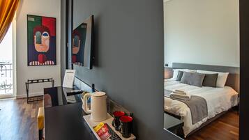 A modern hotel room with a bed, bedside table, and a large mirror.