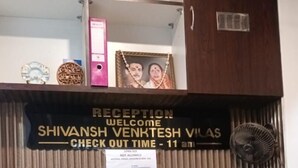 Una reception con un cartello che indica 'RECEPTION SHIVANSH VENKTESH VILAS CHECK OUT TIME - 11 am'.