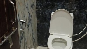 Un bagno con pavimento in marmo, un WC bianco e un angolo doccia.