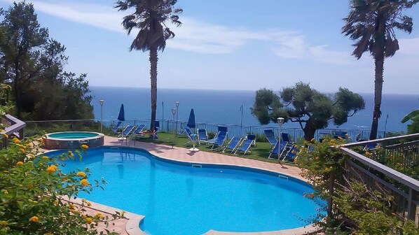 A swimming pool with lounge chairs and a view of the sea. - Nettuno Hotel Palace (Belvedere Marittimo)