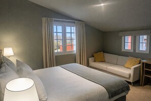 A hotel room with a bed, a sofa, a desk, and two windows. - Hotel Marie Eder (Arcangues)