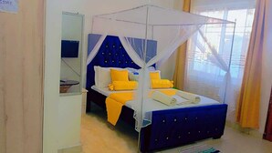 A bedroom with a bed under a canopy, a bedside table, and a mirror. - Lux Suites Rosavosa Apartments Bamburi (Mombasa)