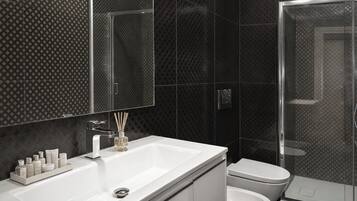 Un baño moderno con lavamanos, espejo y retrete blancos.