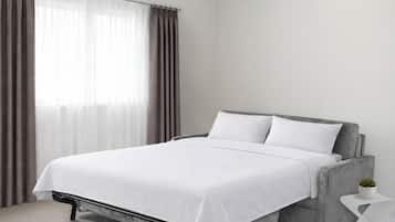 Ein modernes Schlafzimmer mit einem Bett, Vorhängen und einer kleinen Pflanze.