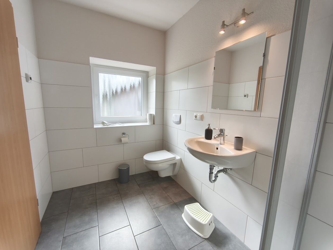 Un baño con inodoro, lavabo y ventana.