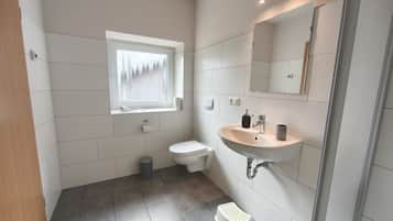 Un baño con inodoro, lavabo y ventana.