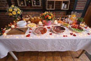 A table set for a meal with various dishes, candles, and a decorative centerpiece. - Pension Malu wo der Tag ab 6 Uhr mit einem guten Frühstück beginnt (Todenbüttel)