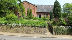 A brick building with a stone wall and a staircase leading to the entrance. - Pension Malu wo der Tag ab 6 Uhr mit einem guten Frühstück beginnt (Todenbüttel)