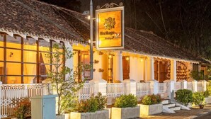 Un hotel de estilo arquitectónico tradicional, con tejado de tejas y fachada bien iluminada.