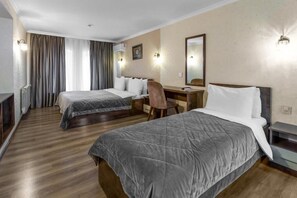 A hotel room with two beds, a desk, a chair, and a mirror. - Moss Hotel  (Baku)