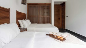 A hotel room with two beds, a wooden wardrobe, a bedside table, and a tray with a book and two cups. - This villa is a 4 bedroom(s), 4 bathrooms, located in Tulum, QR. (Tulum)