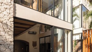 Una casa moderna con fachada de piedra, un amplio ventanal y una piscina.