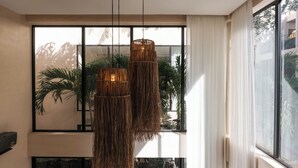 Un interior moderno con ventanas amplias, luminarias tejidas e instalaciones de plantas de interior.