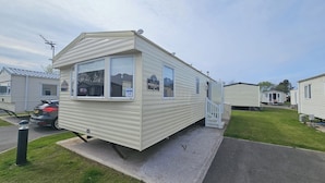 A mobile home with a small porch and a window. - Ty Mawr Chalet Sleeps 6 With Fireplace (Abergele)