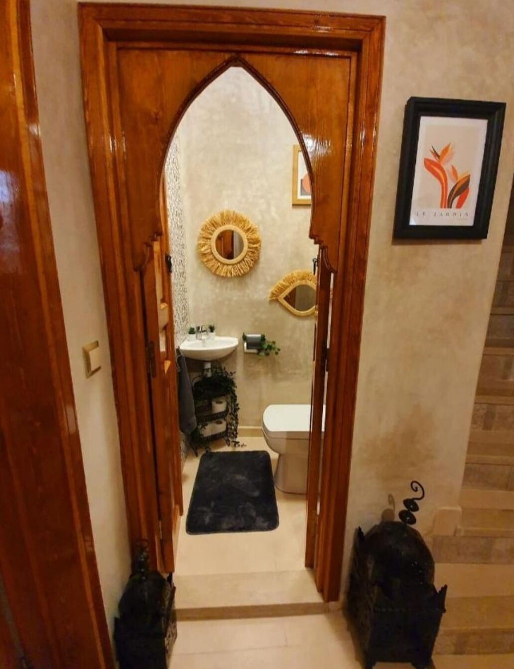 A hallway with a wooden door leading to a bathroom.