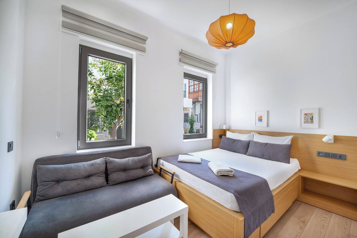 Un dormitorio moderno con cama, sofá y mesa.