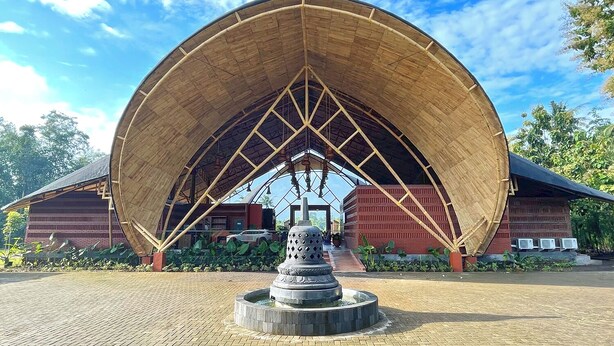 A large, open pavilion with a curved roof structure, surrounded by a paved area and a central fountain. - Moritz Hill Borobudur Resorts & Spa (Borobudur)