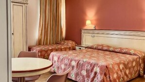 Une chambre avec deux lits, une petite table et une chaise.