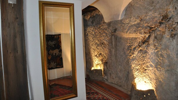 A hallway with a stone wall, a framed mirror, and a patterned rug. - Romantic,central Situated 75m2 Flat (Salzburg)