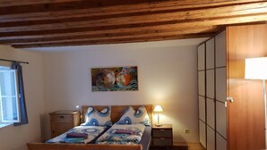 A bedroom with a wooden bed, a nightstand, a lamp, a painting on the wall, and a wardrobe. - Romantic,central Situated 75m2 Flat (Salzburg)