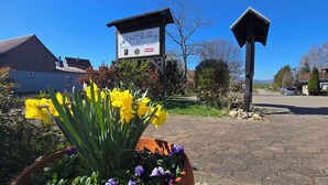A signboard for Hotel Blackberg, a restaurant, and a flower bed with yellow flowers. - Hotel Blocksberg (Wernigerode)