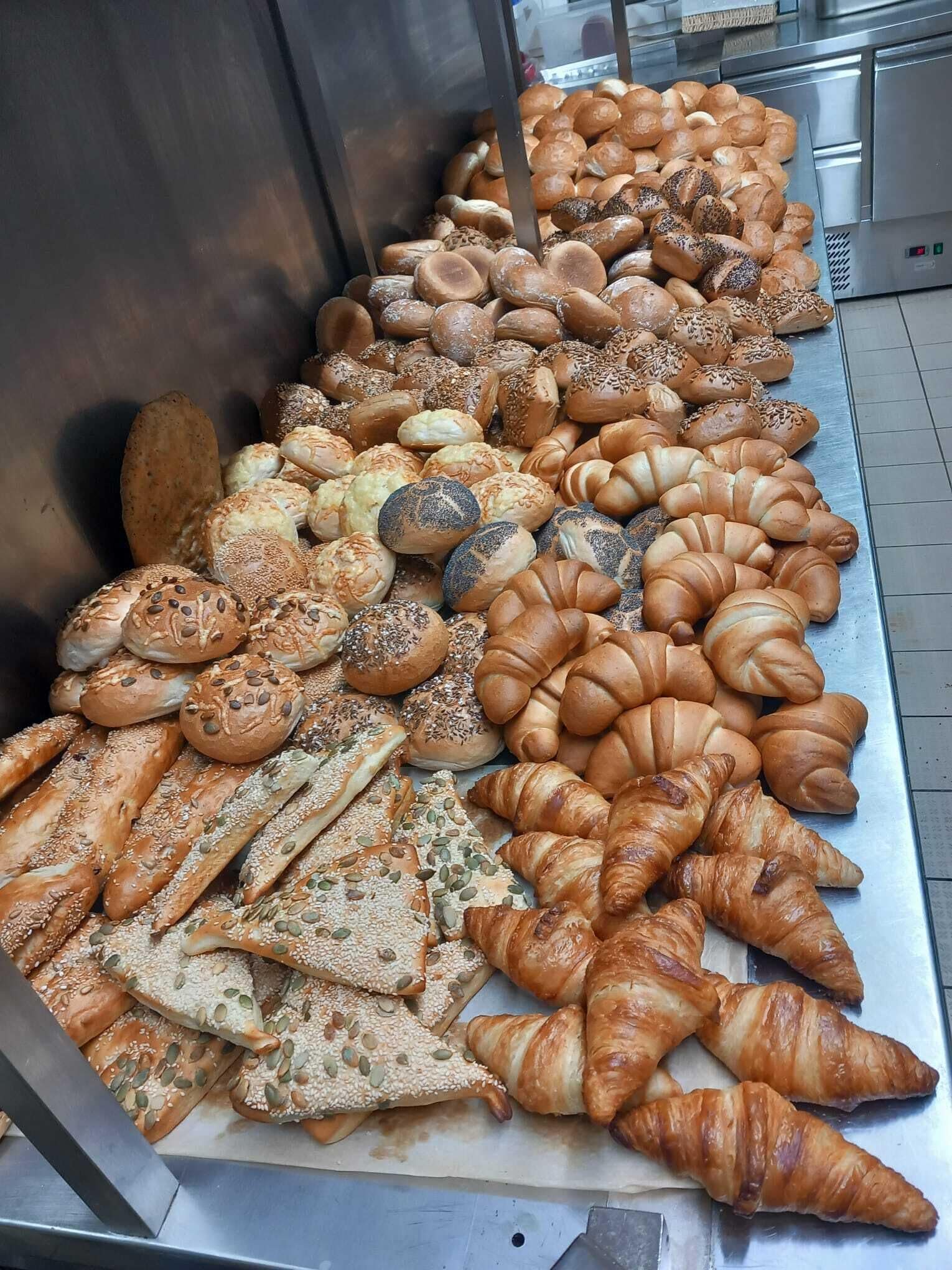 A variety of baked goods displayed on a metal counter.