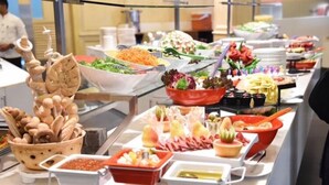A buffet with various food options including salads, meats, and vegetables. - How inn Hotel (Madinah)