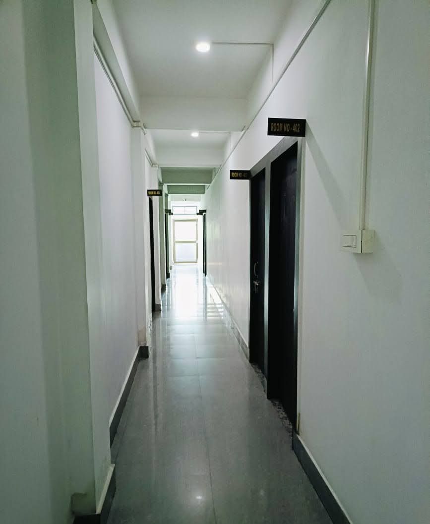 A long, narrow hallway with doors on one side and a clear view of the end of the hallway.