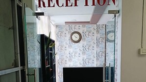 Et receptionområde med et skilt, der siger "RECEPTION" over en døråbning.