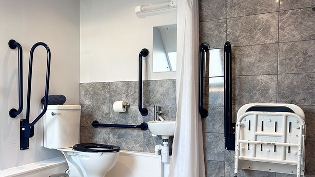 Ein modernes Badezimmer mit Toilette, Waschbecken und Duschbereich.