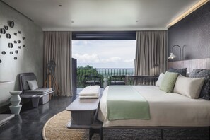 Relax in a spacious room with a large bed, desk, and comfortable chair.