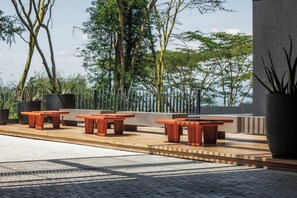 Relax in a serene outdoor space surrounded by lush greenery and a natural backdrop.