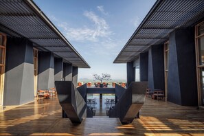 Experience the sleek, open design of this modern building, featuring a central communal space with wooden chairs and tables.