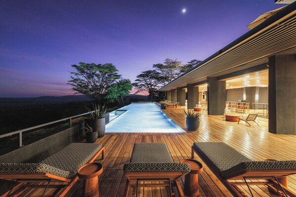 Relax by the pool surrounded by lush greenery and take in the serene views.