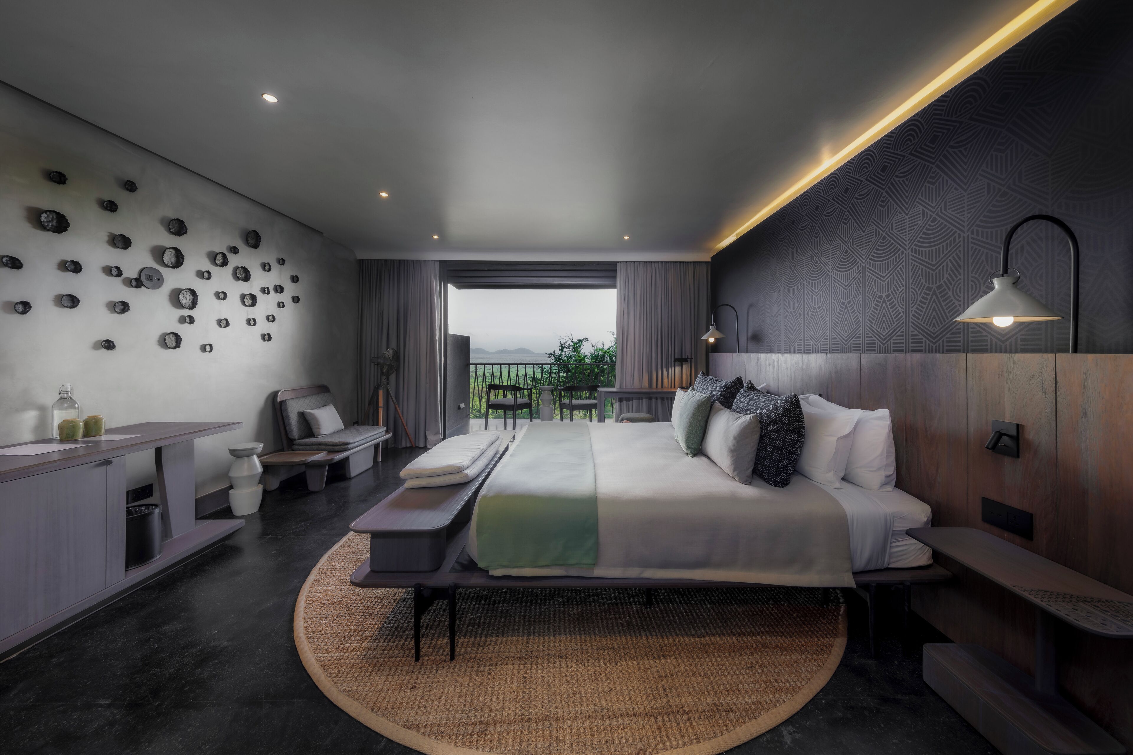 Une chambre d’hôtel moderne, dotée d’un grand lit, d’un bureau, d’une chaise et offrant une vue sur l’extérieur.