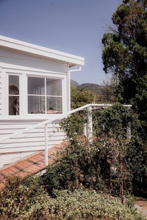 Stunning single-story building with large windows and doors, surrounded by lush greenery and a serene landscape.