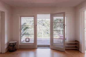 Enjoy a serene retreat with a balcony offering views of lush greenery and a distant building.