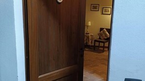 A wooden door with the number 6, leading into a room with a tiled floor and a lamp on a side table. - MATRIMONIAL ROOM with private bathroom, (Radicondoli)