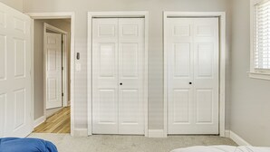 A room with two white doors, a visible doorbell, and a window with blinds. - Conveniently Located North Charleston Home! (North Charleston)