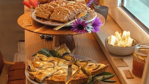 A buffet table with various food items including a pie, cheese, and a bowl of dip.