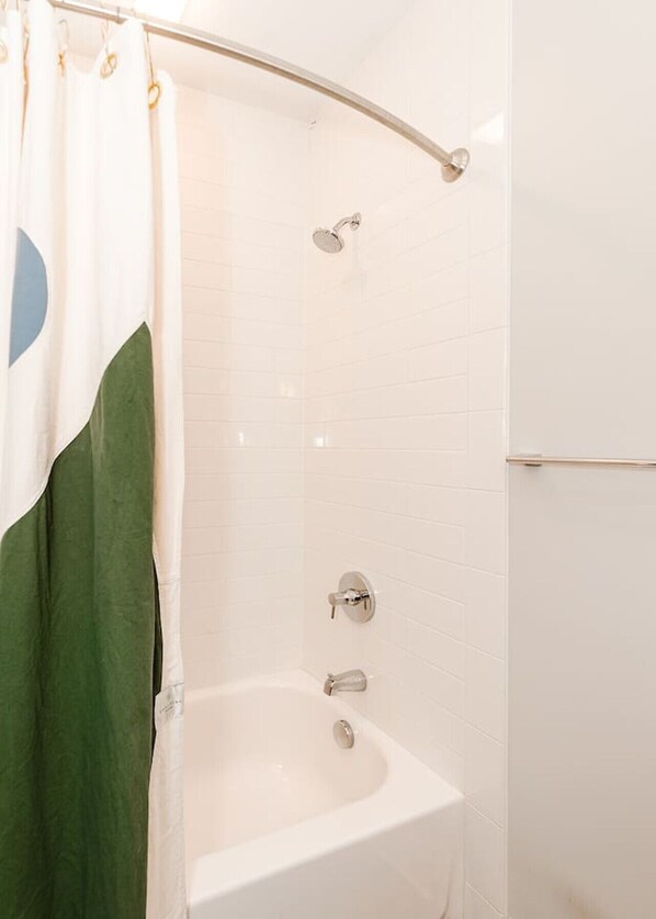 Une salle de bain avec une douche, une baignoire et des toilettes.