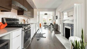 Een moderne keuken met roestvrijstalen apparatuur, een vloerkleed met zebraprint en een open haard.