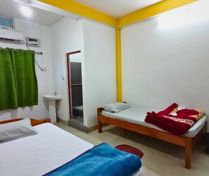 A bedroom with two beds, a sink, and a window. - Hotel Aanggong (Papumpare)