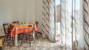 A dining area with a table set for four, covered with a patterned tablecloth. - Cozy apartment in Chianchitta - Pallio with WiFi (Chianchitta - Pallio)